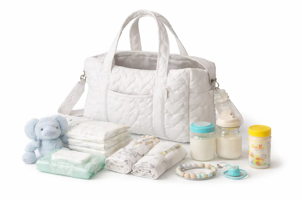 Maman organisant un sac à langer avec les essentiels bébé bien rangés pour une sortie avec poussette