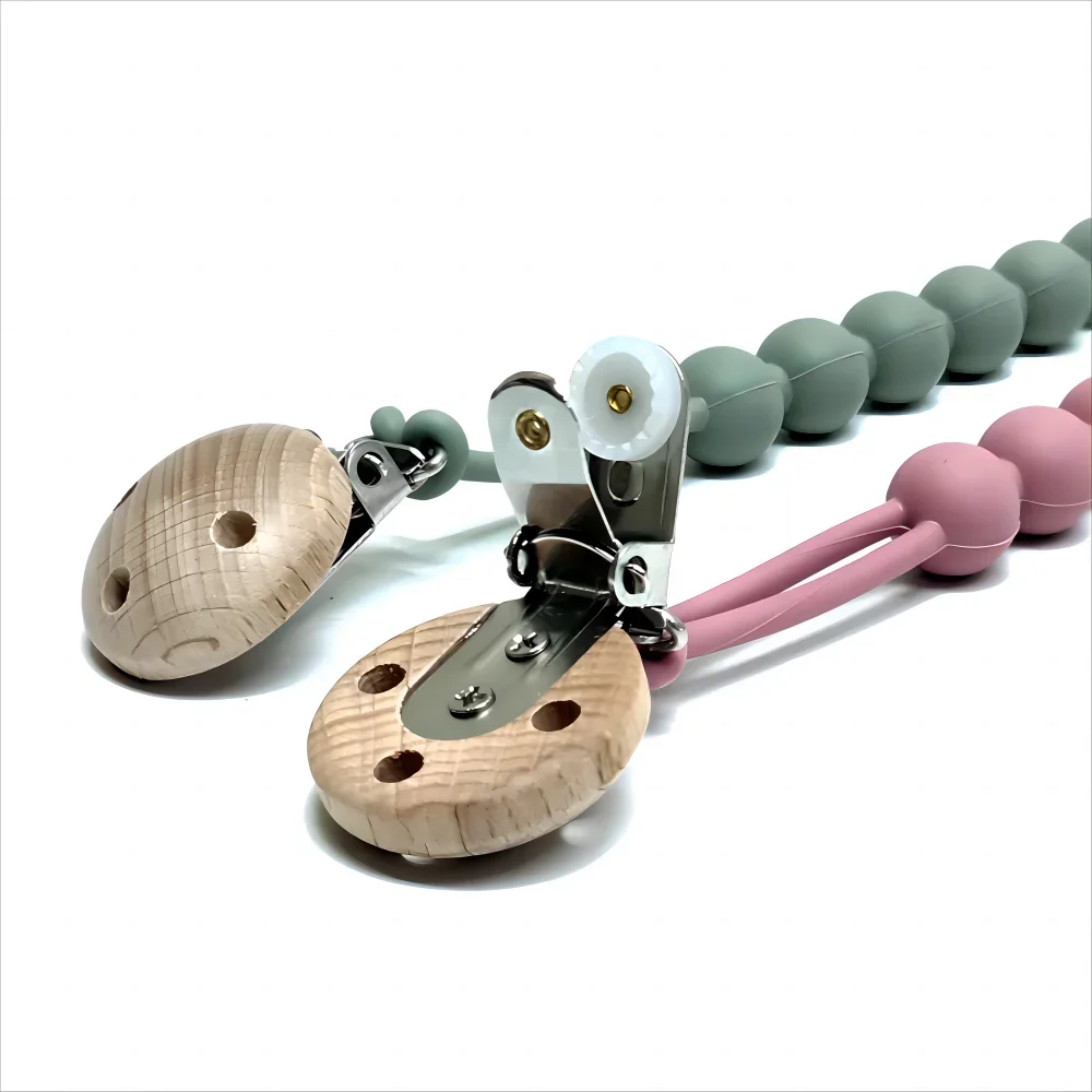 Attache tétine bébé en silicone alimentaire avec perles vert sauge et rose, clip en bois naturel et fixation métallique sécurisée