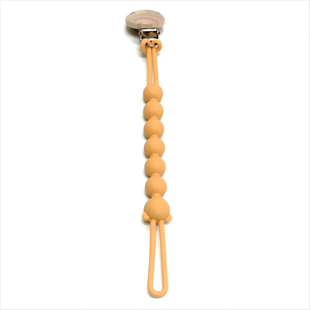 attache tétine jaune sur fond blanc