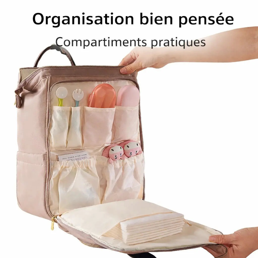 Poche avant d'un sac à langer ouverte avec des rangements spécifiques pour cuillères, couverts et accessoires de soin de bébé.