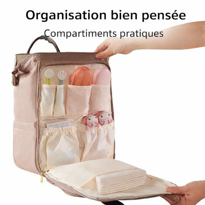 Poche avant d'un sac à langer ouverte avec des rangements spécifiques pour cuillères, couverts et accessoires de soin de bébé.