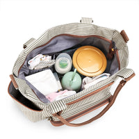 Intérieur du sac à langer rayé avec compartiments organisés contenant biberon, lingettes, vêtements bébé et accessoires.