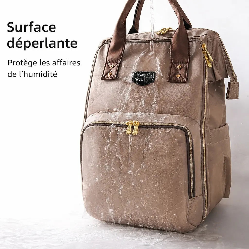 Démonstration de la surface déperlante d'un sac à langer beige sous l'eau, protégeant les affaires de bébé contre la pluie et l'humidité.