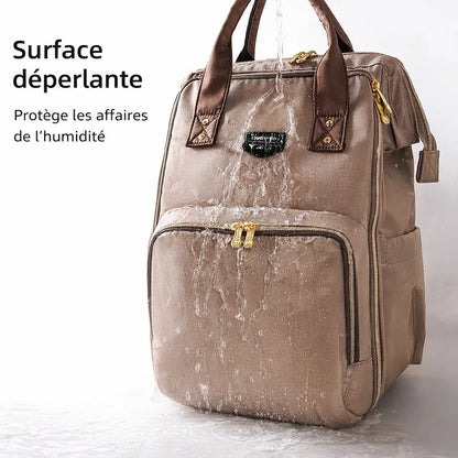 Démonstration de la surface déperlante d'un sac à langer beige sous l'eau, protégeant les affaires de bébé contre la pluie et l'humidité.