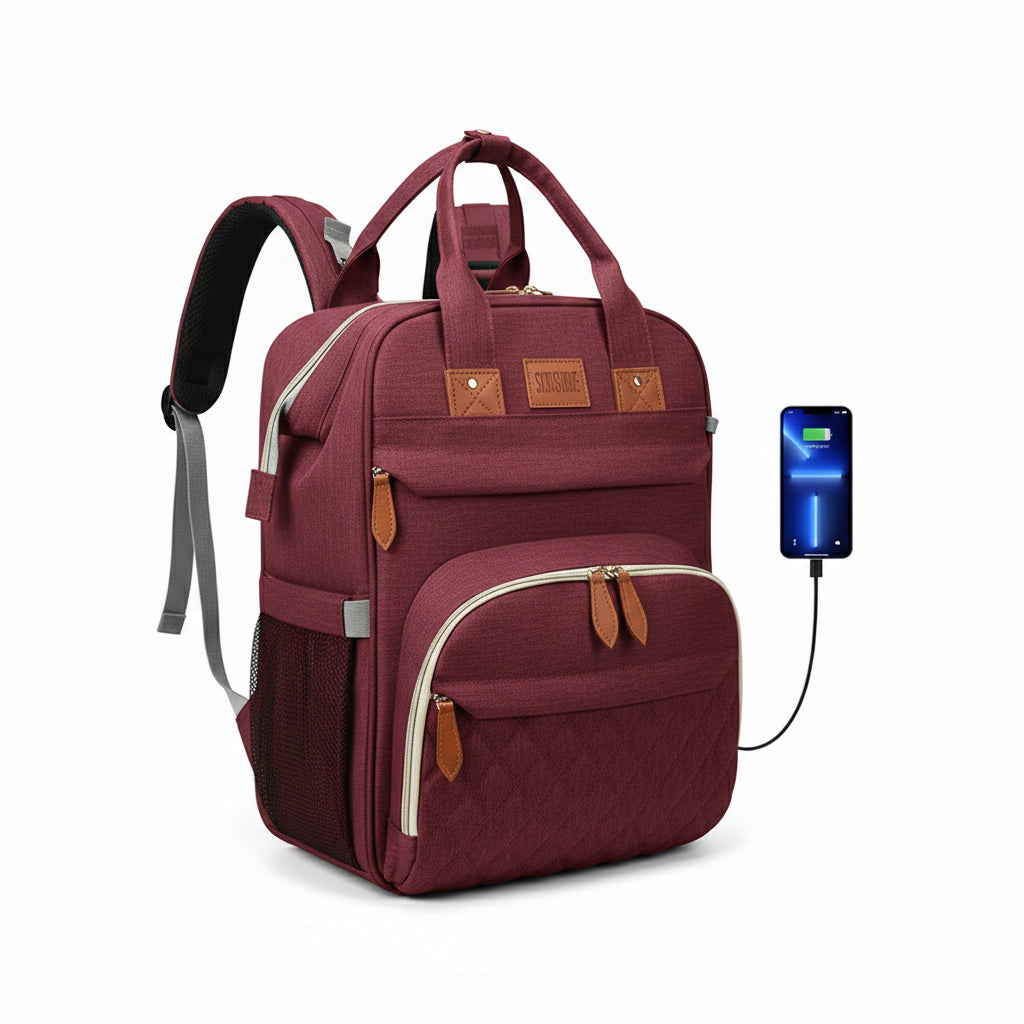 Sac à dos à langer bordeaux multifonction avec port USB externe pour recharge téléphone, finitions effet cuir et poches isothermes.