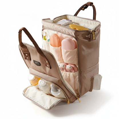 Vue éclatée d'un sac à dos à langer beige ouvert montrant le grand compartiment central, les poches avant pour biberons isothermes, les rangements pour couverts et la fente latérale pour lingettes.