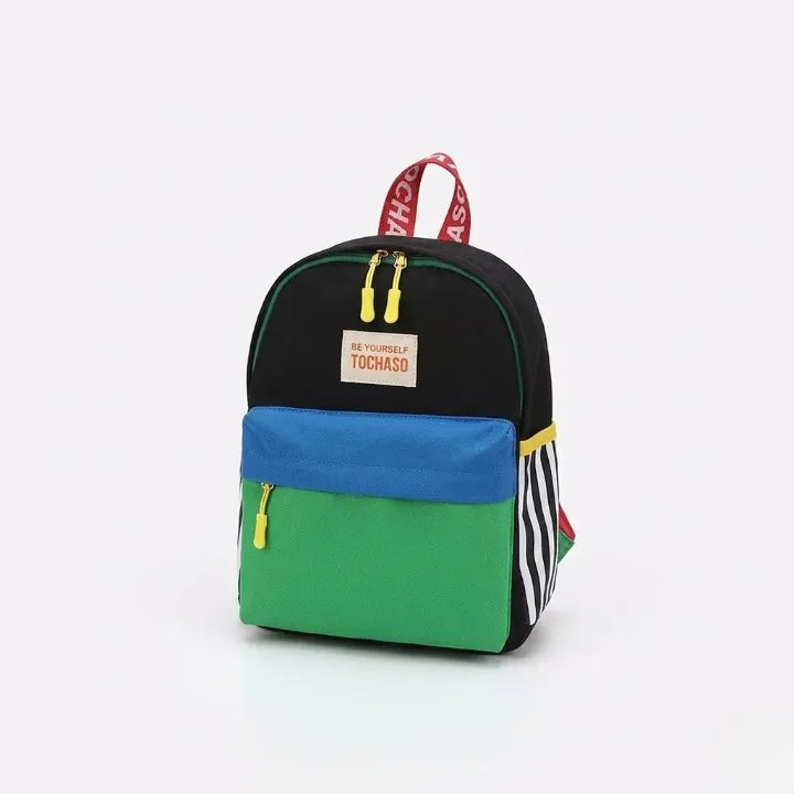 Sac à dos enfant Tochaso colorblock noir vert et bleu avec poignée rouge, zips jaunes et détails rayures, vue de trois quarts