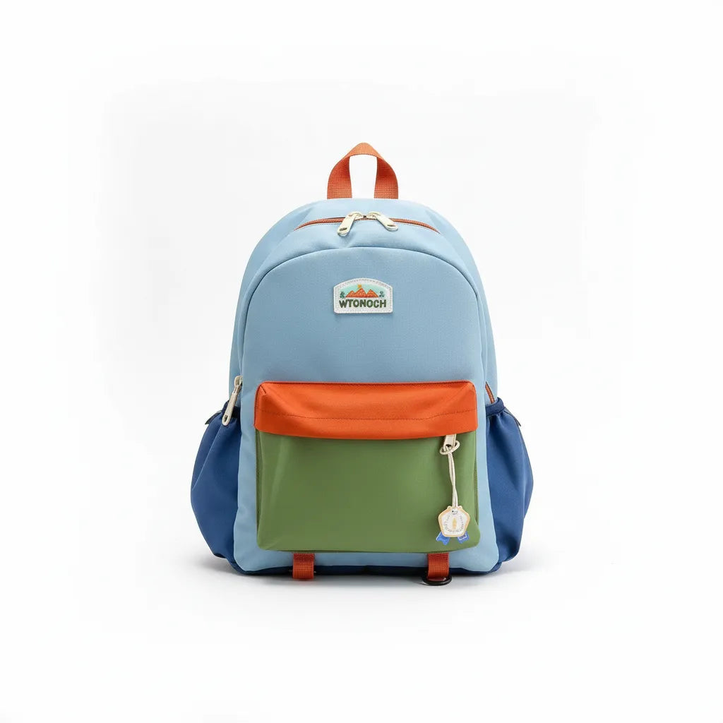 Sac à dos enfant multicolore (orange, jaune, bleu et vert) photographié sur fond blanc en studio, avec poche avant zippée et poches latérales, idéal pour école maternelle et sorties.