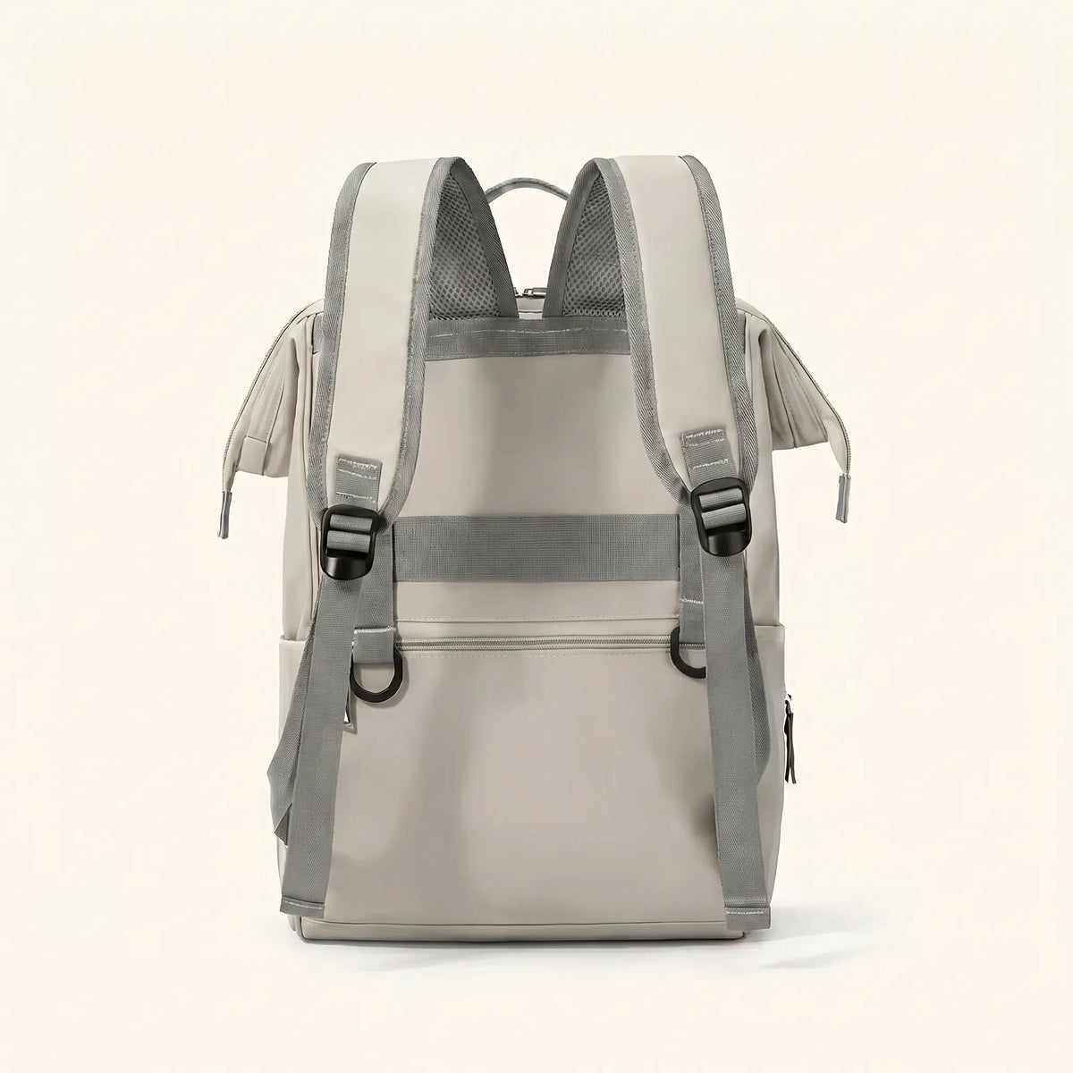 Vue de dos d'un sac à dos à langer beige crème avec bretelles ergonomiques maillées 
grises, sangle poitrine réglable et dos rembourré — design ergonomique et fonctionnel