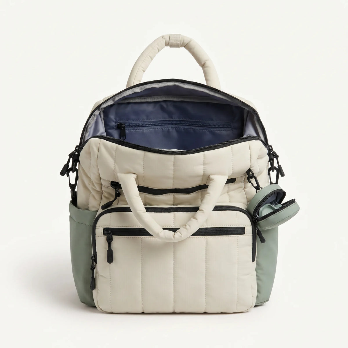 Sac à dos à langer matelassé crème et vert sauge vu de dessus, compartiment 
principal ouvert avec doublure marine, poche latérale accès rapide et 
compatibilité laptop 14 pouces