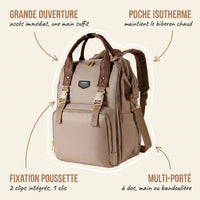 Sac à dos à langer taupe avec anses marron et zips dorés, annotations indiquant la grande ouverture à accès immédiat, la poche isotherme pour maintenir le biberon au chaud, la fixation poussette à 2 clips intégrés et le multi-porté à dos main ou bandoulière