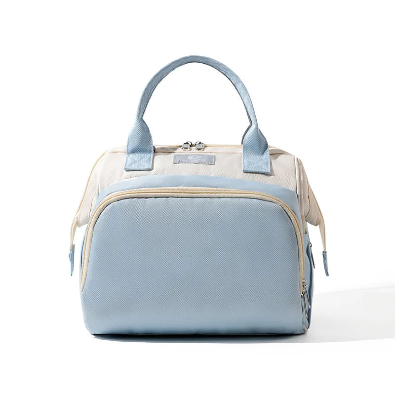 Sac à langer bleu avec poignées bleues et fermeture zippée, format compact pour sorties bébé, vue de face sur fond clair