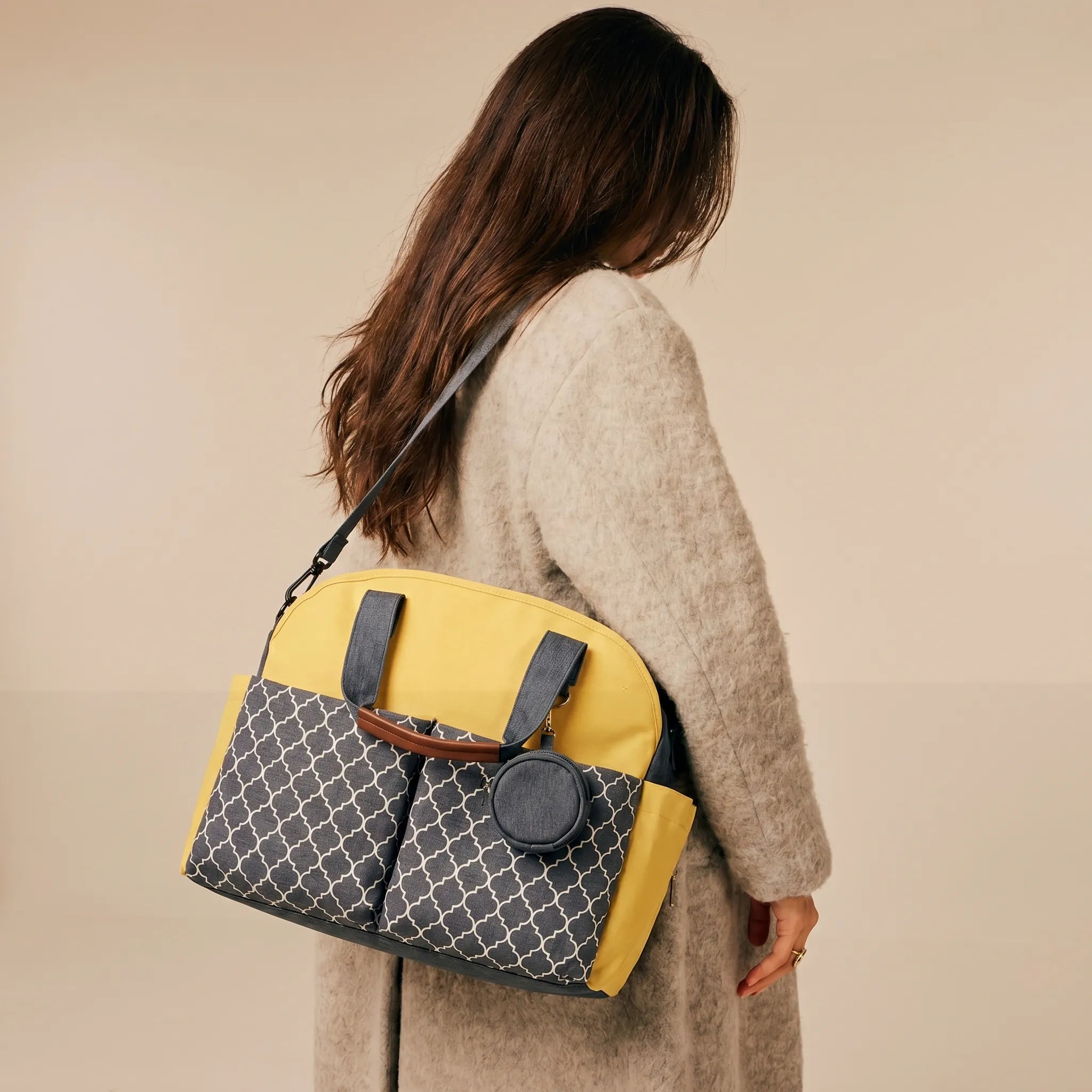 Femme de dos portant un sac à langer bicolore jaune et gris à motifs géométriques marocains en bandoulière