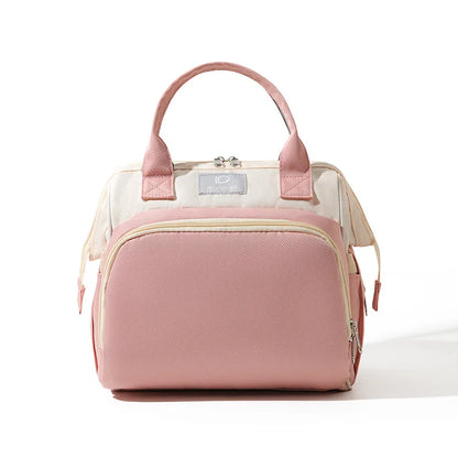 Sac à langer rose avec poignées roses et fermeture zippée, format compact pour sorties bébé, vue de face sur fond clair