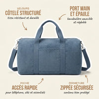 Sac maternité format week-end en velours côtelé bleu jean avec annotations indiquant le velours côtelé structuré résistant et durable, le port main et épaule avec bandoulière amovible et réglable, la poche d'accès rapide pour téléphone et essentiels et la fermeture zippée sécurisée
