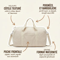 Sac maternité format polochon en velours côtelé crème avec annotations indiquant le velours côtelé texturé coloris épuré, les poignées et bandoulière amovible, la poche frontale zippée pour accès rapide et le grand format maternité minimaliste