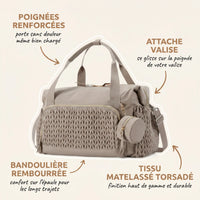 Sac maternité taupe avec tissu matelassé torsadé et pochette ronde assortie, annotations indiquant les poignées renforcées pour porter sans douleur, l'attache valise pratique, la bandoulière rembourrée pour le confort sur l'épaule et le tissu matelassé torsadé haut de gamme