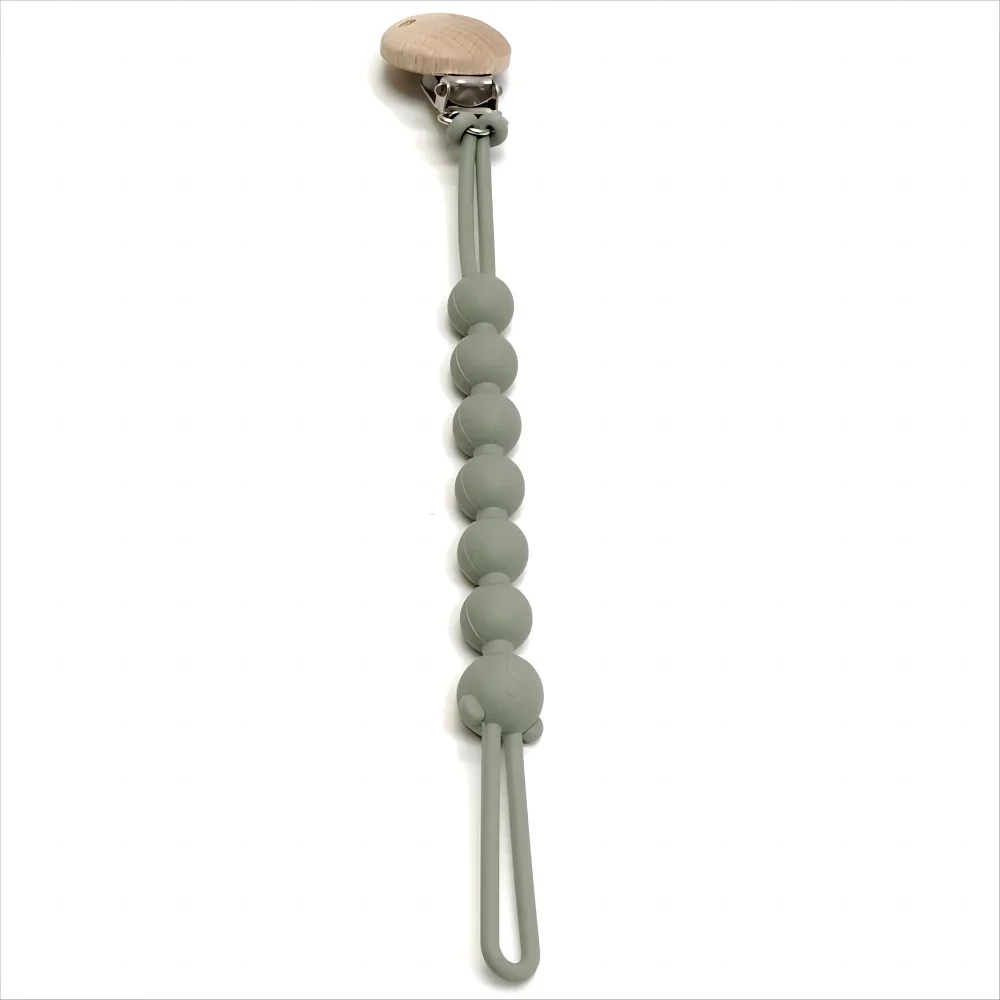 attache tétine vert sur fond blanc