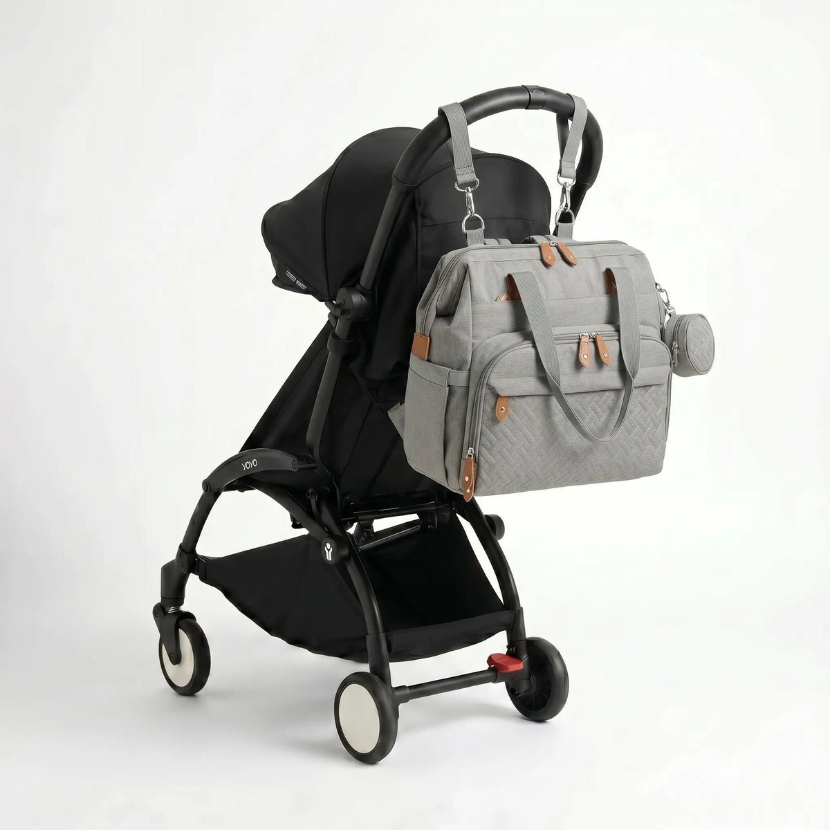 Sac à dos à langer voyage gris attaché à une poussette YOYO avec sangles clipsables et pochette ronde diamant