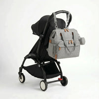 Sac à dos à langer voyage gris attaché à une poussette YOYO avec sangles clipsables et pochette ronde diamant