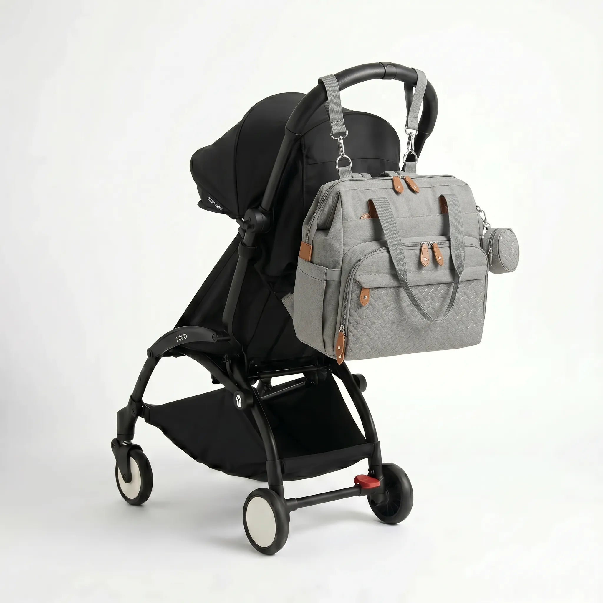 Sac à dos à langer voyage gris attaché à une poussette YOYO avec sangles clipsables et pochette ronde diamant