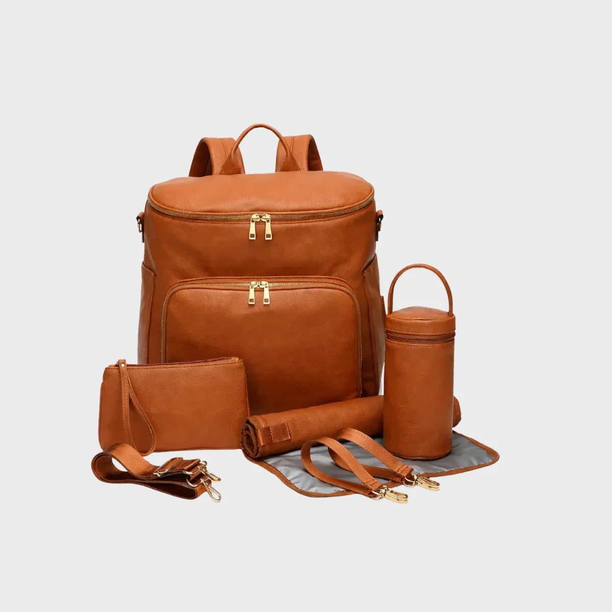 Sac à dos à langer en cuir PU avec poche frontale zippée, pochette assortie, porte-biberon isotherme, tapis à langer et attaches poussette, présenté sur fond blanc studio