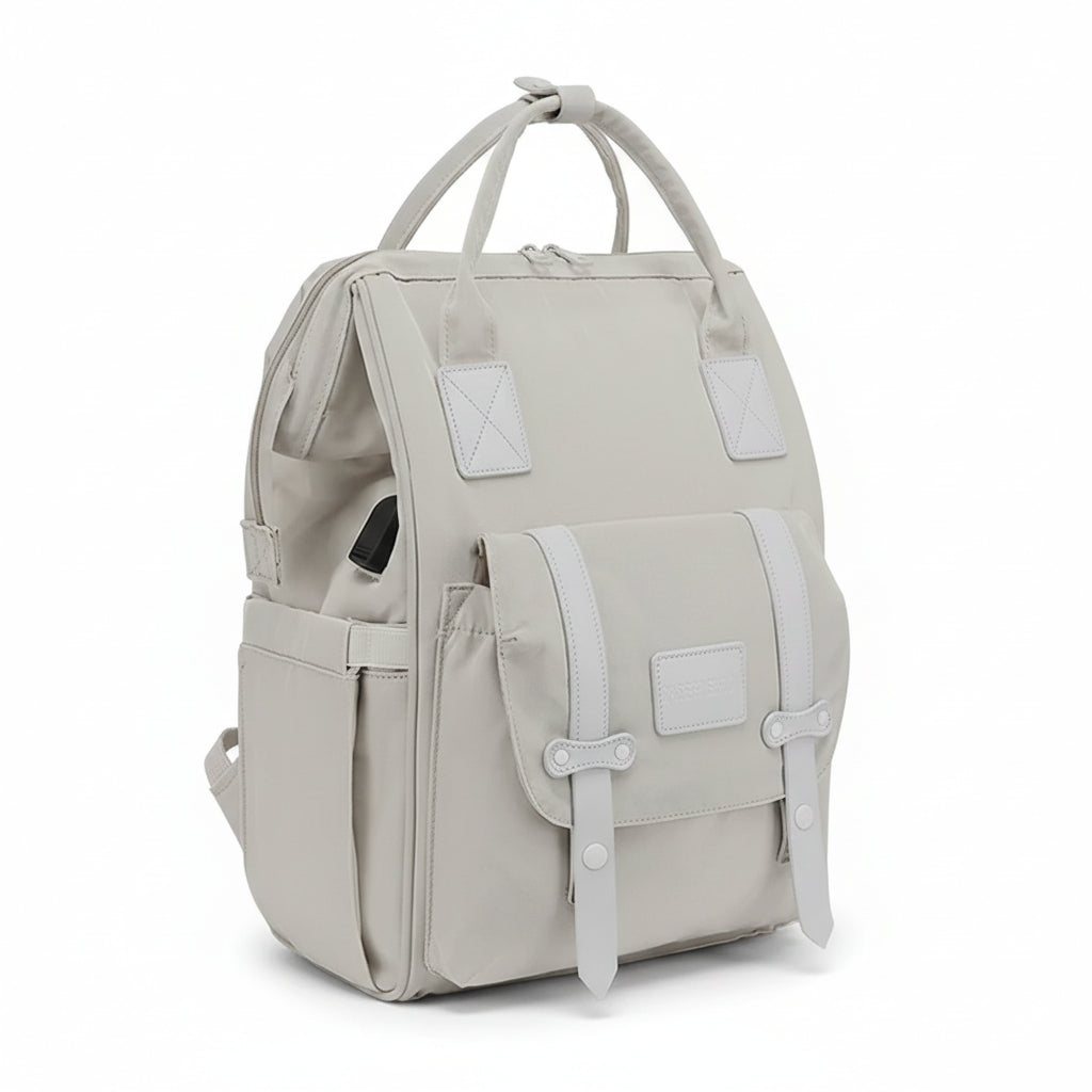 Sac à dos à langer ergonomique beige avec 13 poches de rangement, port USB intégré et sangles de fermeture élégantes.