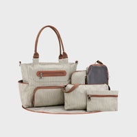 Sac à langer rayé beige et marron présenté avec matelas à langer, pochette, sac biberon et accessoires assortis.