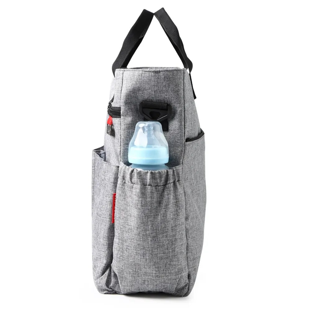 sac à dos à langer de profil qui montre la poche laterale incluant un biberon