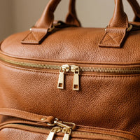 zoom sur le sac a langer en cuir PU, visibilité sur les fermetures zipées et sur la qualité du cuir